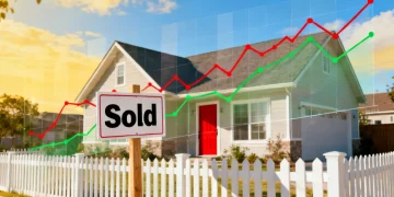 Modern suburban home with 'Sold' sign and financial graphs representing mortgage rates.